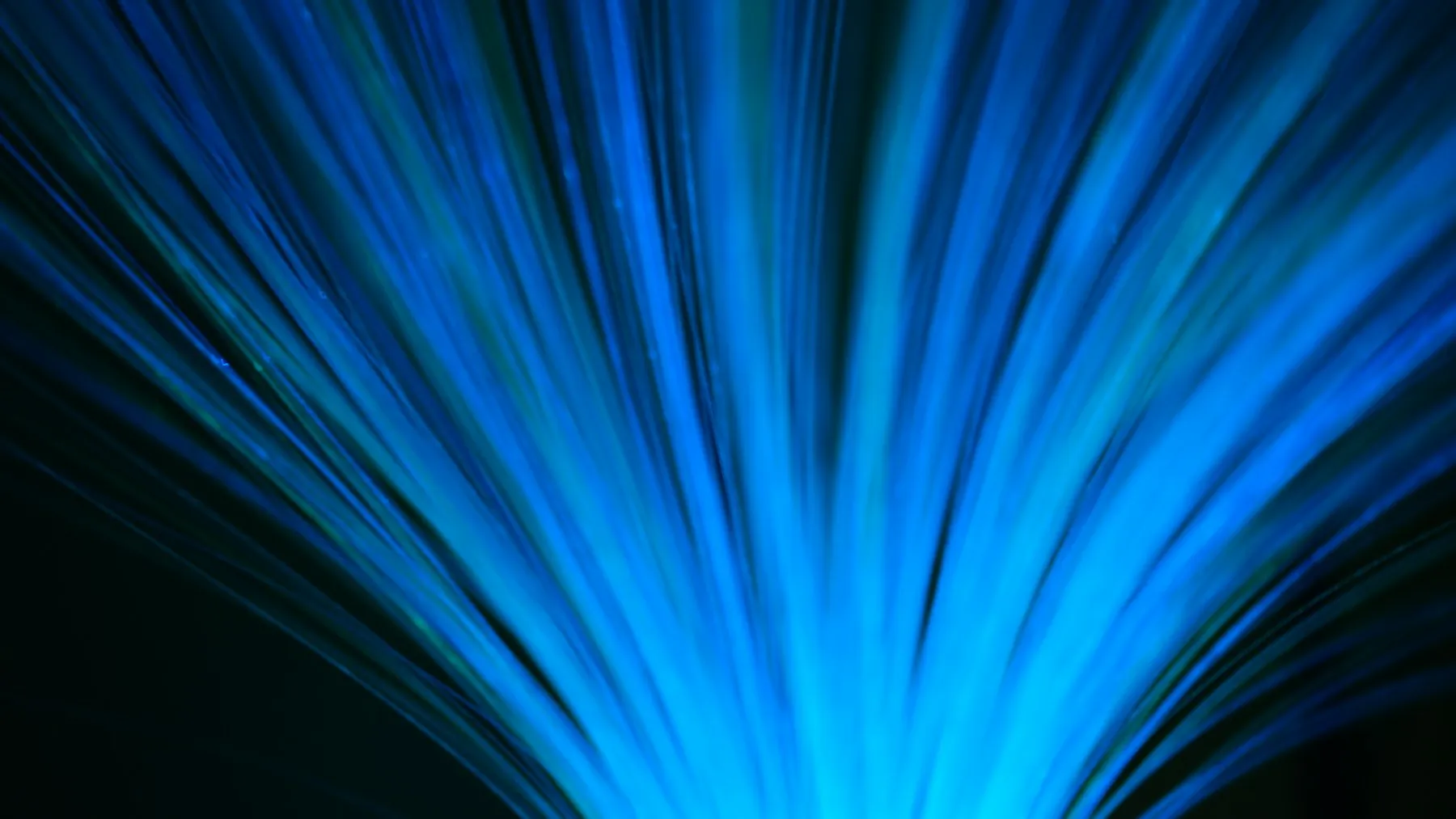 Blue fibre optic strands radiating outwards in the dark